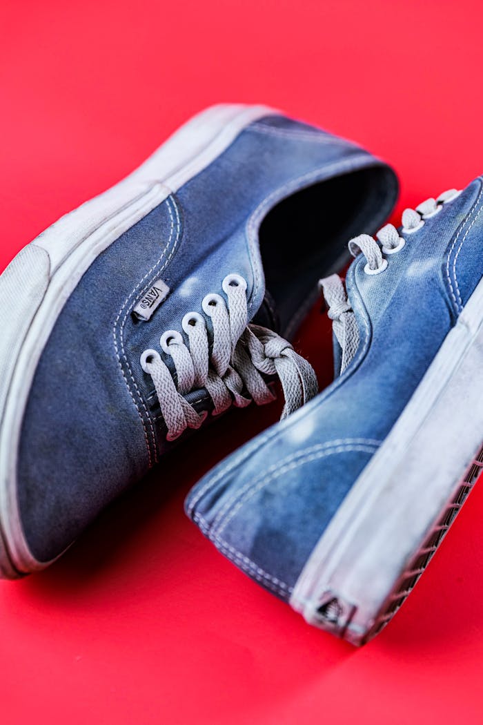 services-02 Close-up of stylish blue sneakers on a vibrant red backdrop. Perfect for fashion or lifestyle themes.