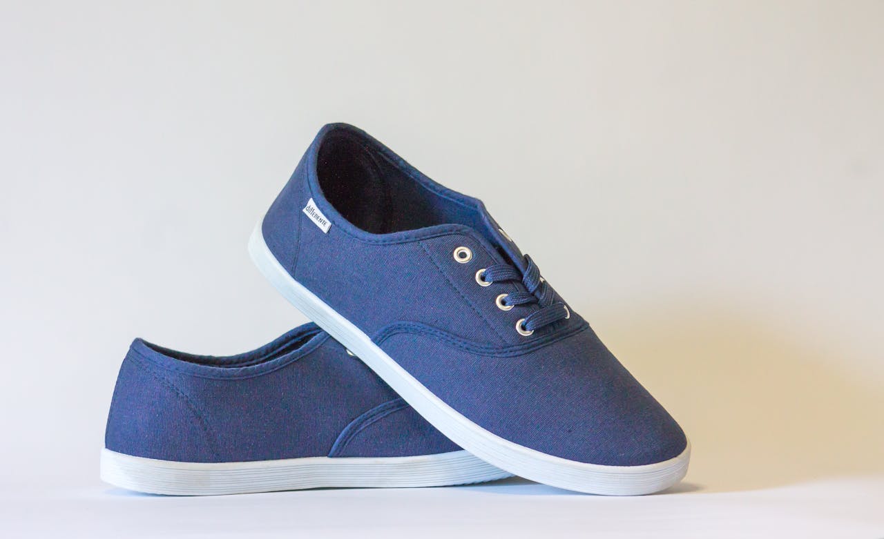 hero-img-01 Pair of stylish blue canvas shoes with white soles displayed against a neutral background.